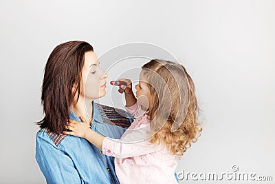 Mother and her child daughter girl with a lipstick. Portrait of Stock Photo