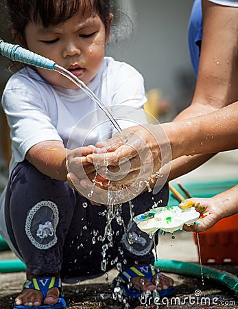 Mother and her child washing hands together after painted Stock Photo