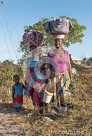 Kenyan Giriama family carrying bundles on head Editorial Stock Photo