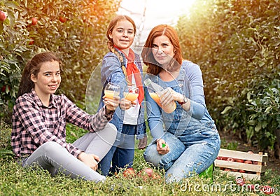 Mother with her children enjoy in natural juice of fruit from her garden Stock Photo