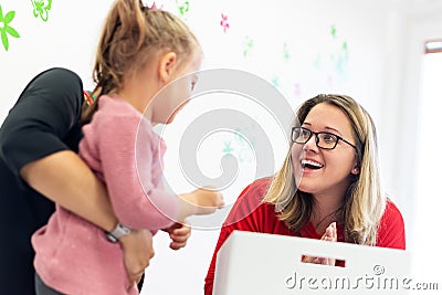 Mother and her daughter in child occupational therapy session doing sensory playful exercises with the child therapist. Stock Photo