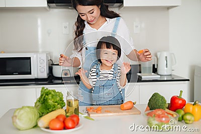Mother with her daughter in the kitchen cooking together Stock Photo