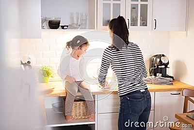 Mother with her daughter in the kitchen cooking together Stock Photo