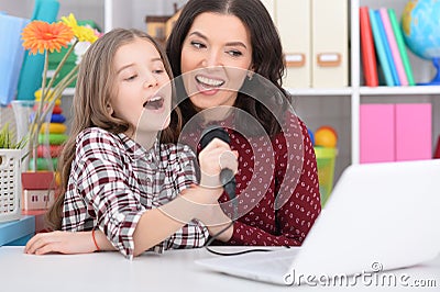 Mother with her daughter singing karaoke Stock Photo