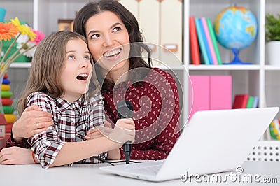 Mother with her daughter singing karaoke Stock Photo