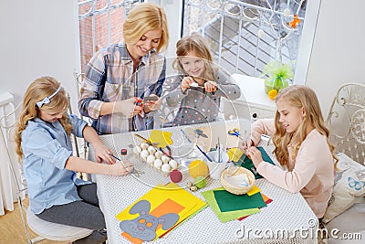Mother and her daughters painting and decorating easter eggs. Stock Photo