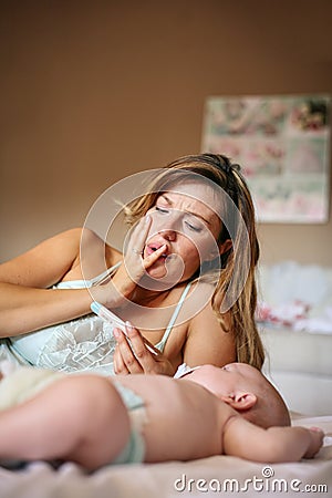 Mother with her little baby boy at home. Worried mother checks Stock Photo