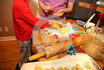 Mother and her little baby making hands cookies at home in the kitchen Stock Photo