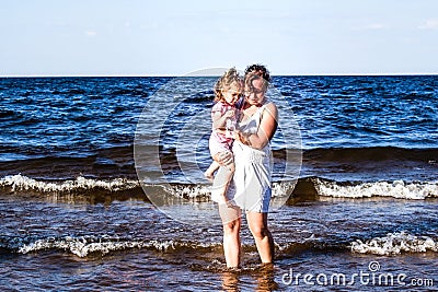 Walk daughter with her mother on the nature near the water. Stock Photo