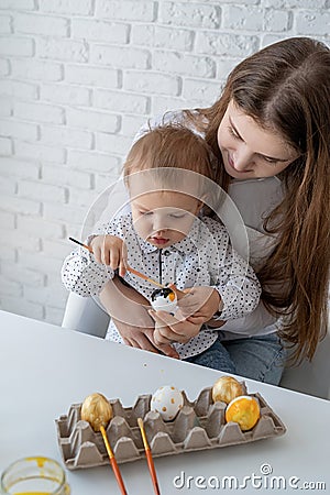 Mother and her little son learning to paint easter eggs Stock Photo