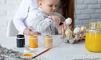 Mother and her little son learning to paint easter eggs Stock Photo