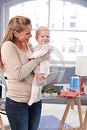 Mother holding baby girl in arms smiling Stock Photo