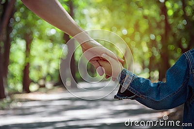 mother holding a child`s hand, close-up hands, nature in backgr Stock Photo