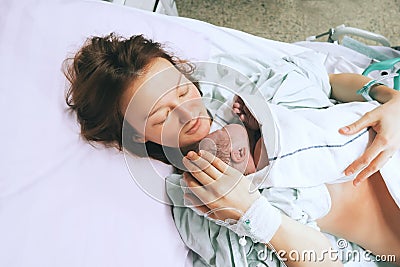 Mother holding her newborn baby after labor in a hospital. Stock Photo