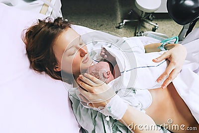Mother holding her newborn baby after labor in a hospital. Stock Photo
