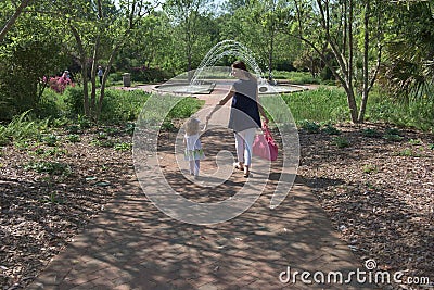 Mother holds her daughter`s hand in an outdoor park. Editorial Stock Photo