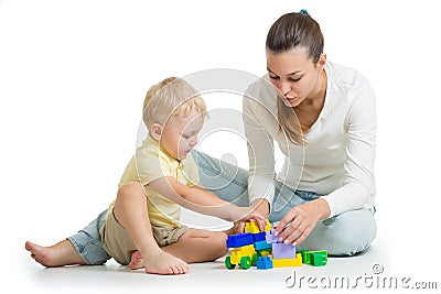 Mother and kid build out of colorful plastic blocks. Family and childhood concept Stock Photo