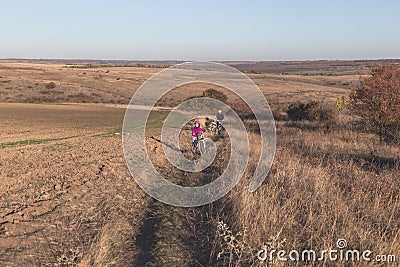 Mother and kids on their bikes go up the hill Stock Photo