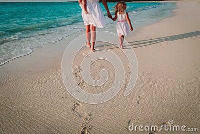 Mother and kids walking on beach leaving footprint in sand Stock Photo