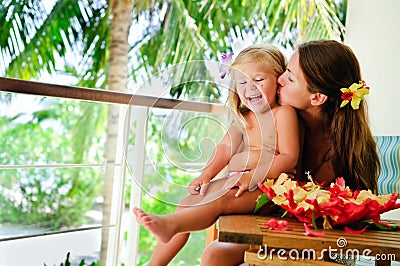 Mother kiss her daughter at tropical garden Stock Photo