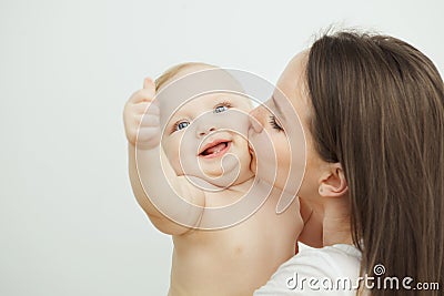 Mother kisses her adorable toddler in cheek, enfant posing Stock Photo