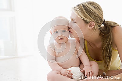 Mother kissing baby indoors Stock Photo