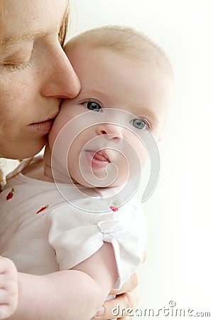 Mother kissing little baby smiling Stock Photo