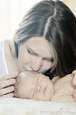 Mother kissing newborn baby Stock Photo