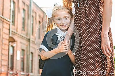 The mother leads the little girl student to the first grade hand in hand. Back to school. The beginning of the lessons. First day. Stock Photo