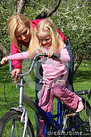 Mother learns daughter to go by bicycle Stock Photo