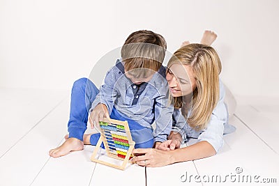 Mother learns to calculate with son on a white floor Stock Photo