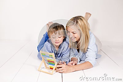 Mother learns to calculate with son on a white floor Stock Photo