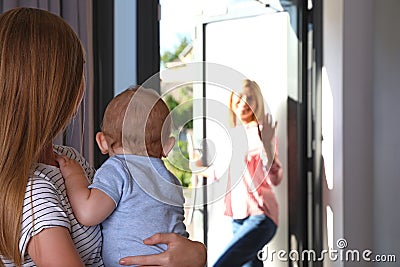 Mother leaving her baby with teen nanny Stock Photo