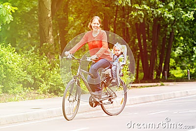 Mother and little daughter on bike in summer Stock Photo