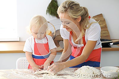 Mother and little daughter are cooking in the kitchen. Spending time all together or happy family concept Stock Photo