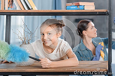 Mother and little daughter with duster cleaning home Stock Photo