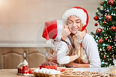 Mother and little girl baking Christmas pastry. Children bake gingerbread. Stock Photo