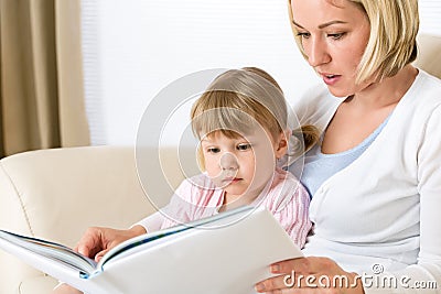 Mother with little girl read book together Stock Photo