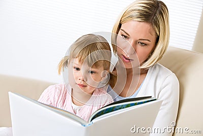 Mother with little girl read book together Stock Photo