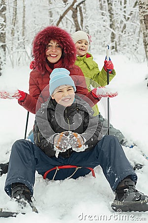 Mother, little son and daughter ride on sled Stock Photo