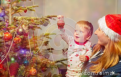 Mother and little toddler decorate Christmas tree Stock Photo