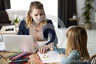 Mother looks after her daughter during home office Stock Photo