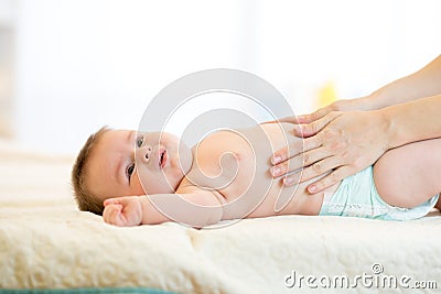 Mother massaging crying baby with colic Stock Photo