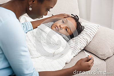 Mother measuring temperature of her sick daughter Stock Photo