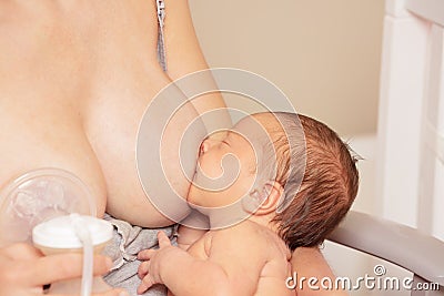 Mother multitasking using breast pump and breastfeed Stock Photo