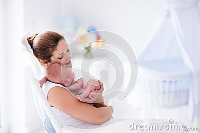 Mother and newborn baby in white nursery Stock Photo