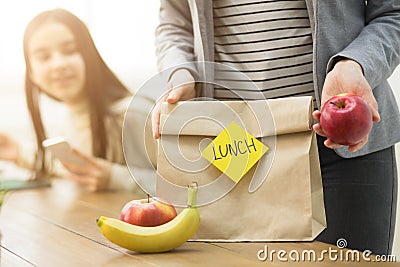 Mother Packing Healthy School Lunch For Daughter Stock Photo