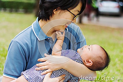 Mother parenting baby on park Stock Photo