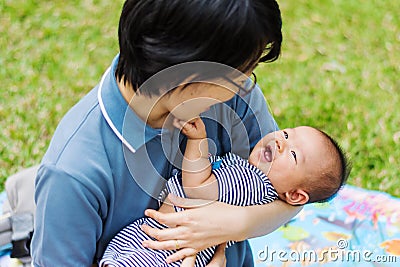 Mother parenting baby on park Stock Photo