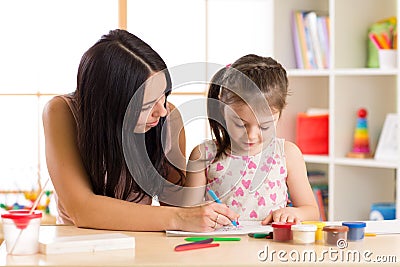 Mother playing with her child daughter, drawing together Stock Photo